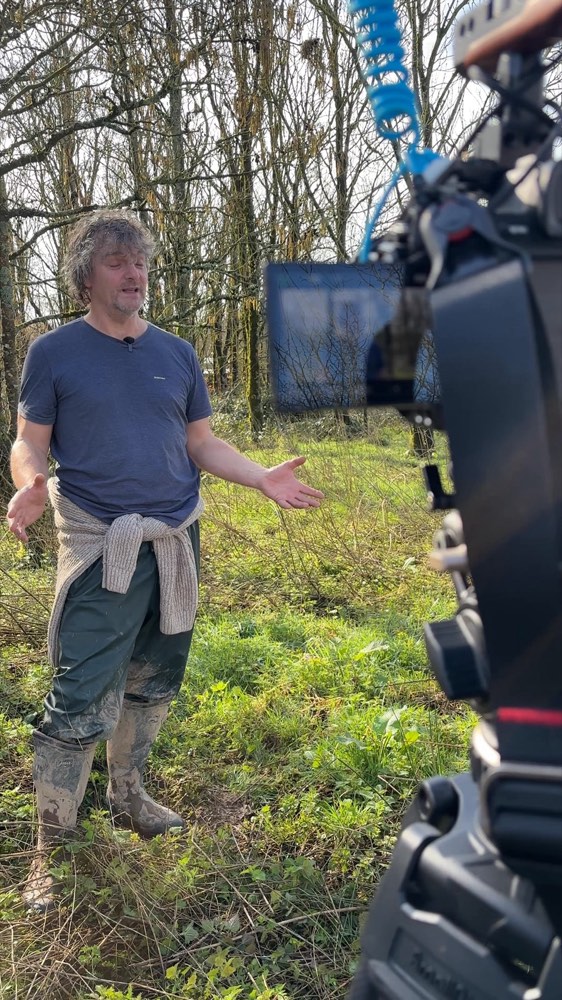 Filming a documentary interview outdoors, behind the scenes